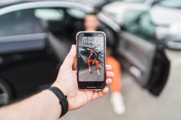 Person sitting in the car seen through a phone camera