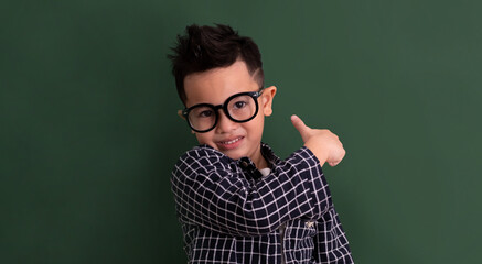 Asian Little boy in casual smile on blackboard.