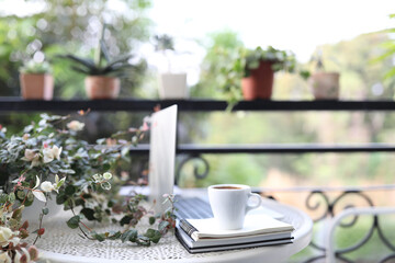 Laptop side view white mock and coffee cup with notebooks on white table outdoor