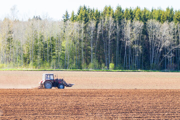 tractor plows the field on a sunny spring day