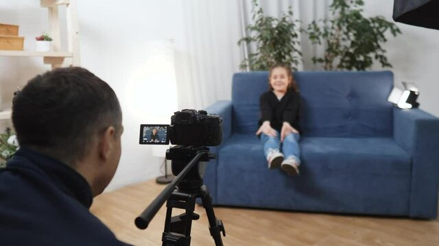 kid video blogger. videographer shoots a video blog in a studio with a little girl for an online platform. kid dream blogger backstage records vlog on camera. little youtuber girl