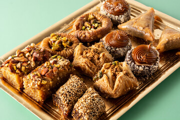 Assortment of Ramadan dessert baklava on green background