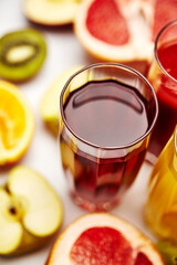 freshly squeezed fruit juice in glass glasses with a composition of fruit on a light background