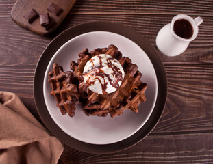 Homemade chocolate waffles with ice cream decorated chocolate syrup.
