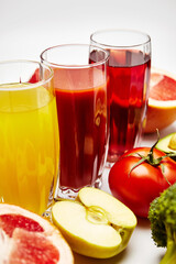 freshly squeezed fruit juice in glass glasses with a composition of fruit on a light background