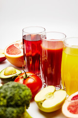 freshly squeezed fruit juice in glass glasses with a composition of fruit on a light background
