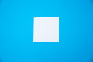 Blank white To Do List Sticker. Close up of reminder note paper on the blue background. Copy space. Minimalism, original and creative photo.