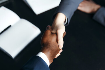 Photo of shaking hands of business partners over the table. Successful completion of negotiations