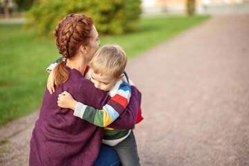 Child with rucksack and with mother infront of a school building