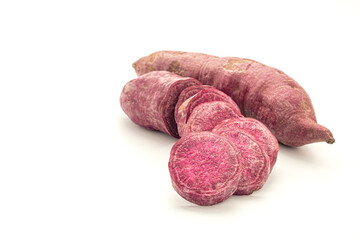 Purple yams or purple sweet potatoes on white background. Side view. Vegan fruit and healthy fruits concept
