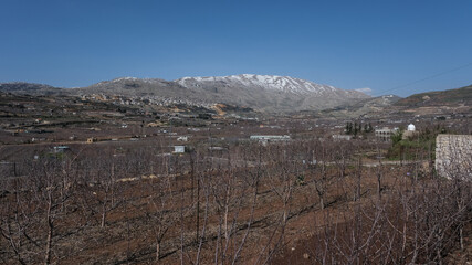 The Druze town of Majdal Shams, as seen from Mas'ade village,  on the north-eastern part of the Golan Heights with the Hermon Mountain ridge and the Israeli-Syrian border, Israel. 