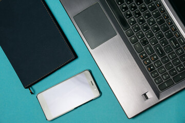 Flat lay, notepad, laptop and smartphone on a blue background, copy space, for a banner
