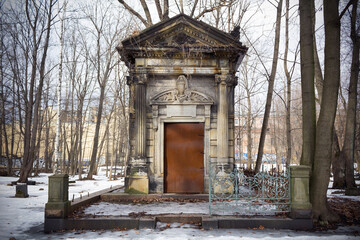 Crypt of Horwitz family, large stone tomb among snow and bare trees - Smolenskoe Lutheran Cemetery, Russia, Saint Petersburg, March 2021