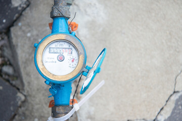 Top view water meter on cement background. Sanitary equipment.