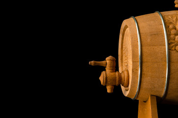 wooden barrel with a dispenser of Georgian wine on a black background. copyspace