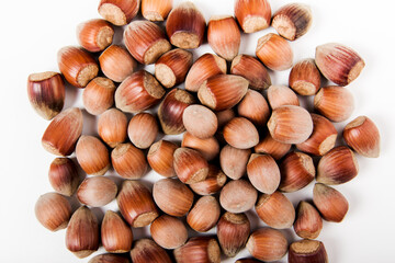 flatlay of whole unpeeled hazelnut on the white background. close-up view