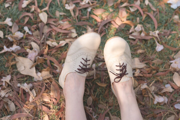 leg of woman relax under tree with pink flower on floor in spring season