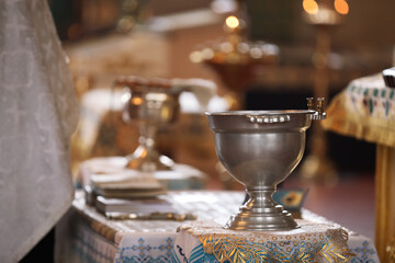 Silver vessel with holy water on stand in church. Baptism ceremony