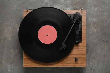 Turntable with vinyl record on grey background, top view