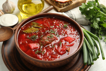 Stylish brown clay bowl with Ukrainian borsch served on white wooden table