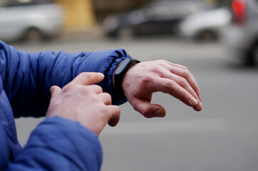 fitness bracelet on a man's hand close-up on a blurred city background