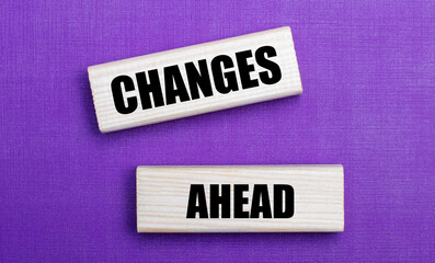 On a lilac bright background, light wooden blocks with the text CHANGES AHEAD