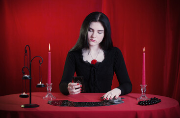 young girl guessing with tarot cards on  red background