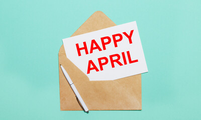On a light blue background lies an open craft envelope, a white pen and a white sheet of paper with the text HAPPY APRIL
