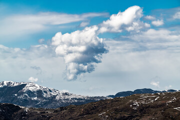 Cloud over snow capped mountain peaks