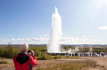 Iceland Geyser Strokkur Eruption on a beautiful sunny summer day, with unrecognizable faces tourists