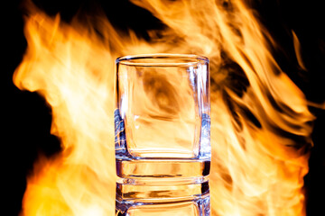 glass for alcohol in the background of fire