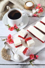 Homemade panna cotta and red fruits cubes in coconut flakes and cup of coffee, blooming japanese...
