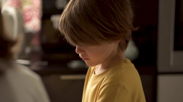 Children cooks pizza. Boy helps father. Prepering ingredients for pizza. Child pouring cheese