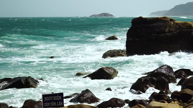 Turquoise sea waves crush on rocks of Hang Rai coast, Vietnam