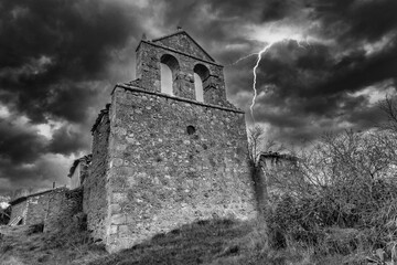 An abandoned hermitage in black and white under a storm