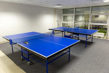 Two blue ping pong tables in the room