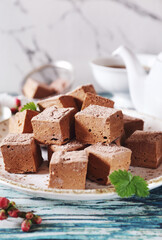 Homemade chocolate marshmallows cubes sweets and cup of tea
