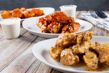 A view of three plates of chicken wings.
