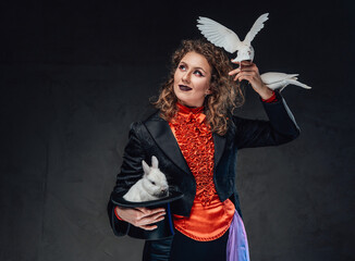 Brown haired female artist with a rabbit and two doves in dark background