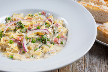 A view of a plate of farfalle pasta with Alfredo sauce.