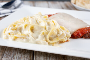 A view of a plate of fettuccine Alfredo and chicken parmigiana.