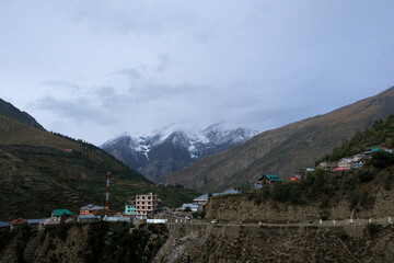 Naklejka premium A quiet village in the middle of the mountains with snow-capped peaks in the Himalayas of India