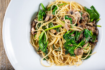 A top down view of a plate of spaghetti and mushrooms.