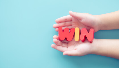 win word on kid hands blue background concept.victory, success, game win, School education, award, reward, casino lucky draw, champion sport.win word for sport in school .Strategy, deal, teamwork.