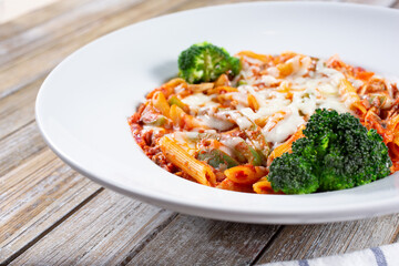A view of a plate of mostaccioli pasta in marinara.