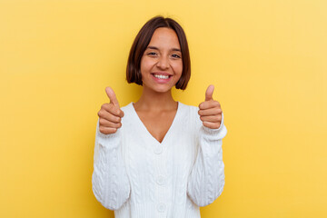 Young mixed race woman isolated on yellow background with thumbs ups, cheers about something, support and respect concept.