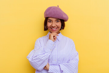 Young mixed race woman wearing a beret isolated on yellow background smiling happy and confident, touching chin with hand.