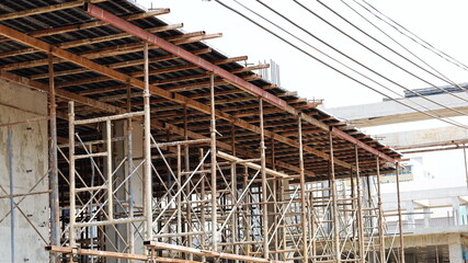 Metal scaffolding on the construction site. Temporary scaffolding is used as a formwork support for pouring liquid cement in the construction of tall buildings. Selective focus