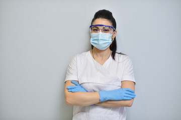 Fototapeta na wymiar Cute woman dentist in uniform, protective glasses and face mask.