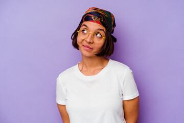 Young mixed race woman wearing a bandana isolated on purple background dreaming of achieving goals and purposes